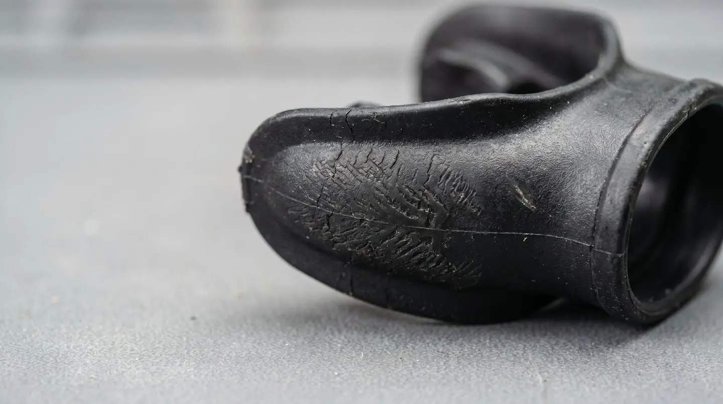 Gros plan sur embout de détendeur en silicone noir montrant des signes d'usure et fissures sur surface technique